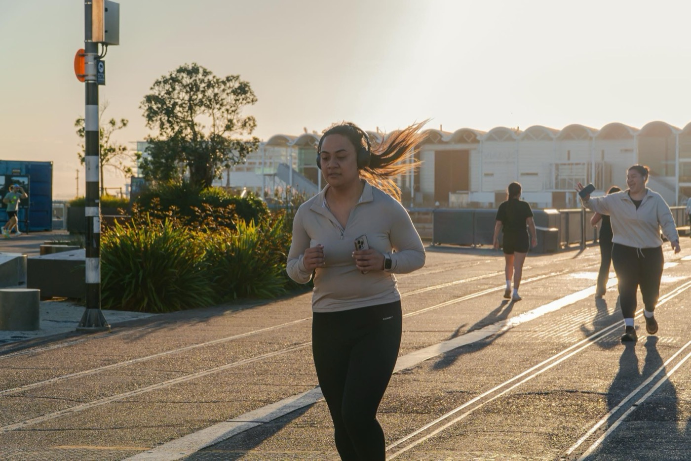 A runner moving along the waterfront in the warm light of morning