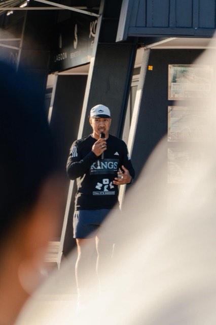 An NTIB coach standing with the crew after a session