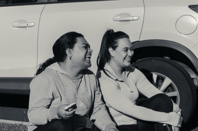 Two teammates laughing together after a session