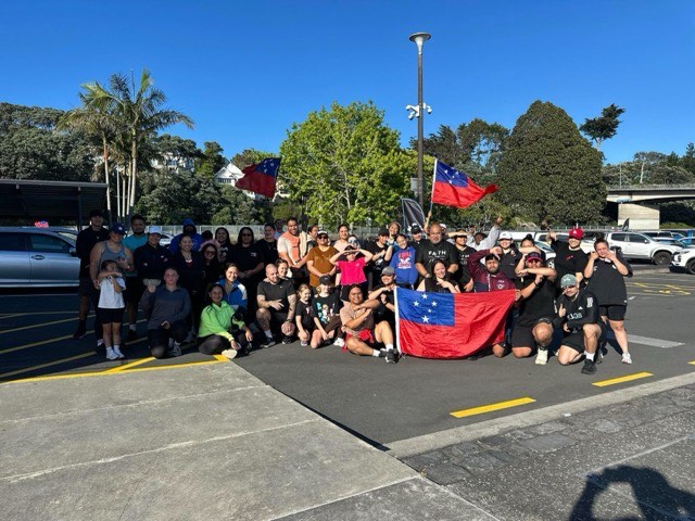 The NTIB crew gathered together with flags at the waterfront