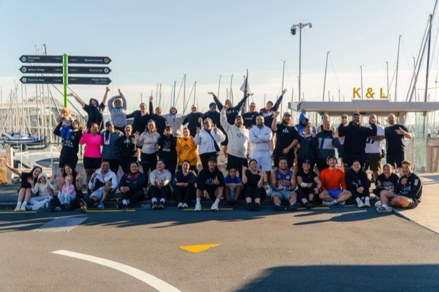 A large group of NTIB runners gathered together on a waterfront route