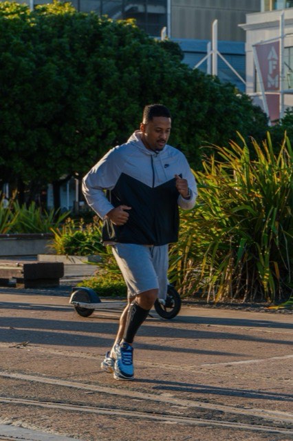 A runner wearing blue training gear on a city route